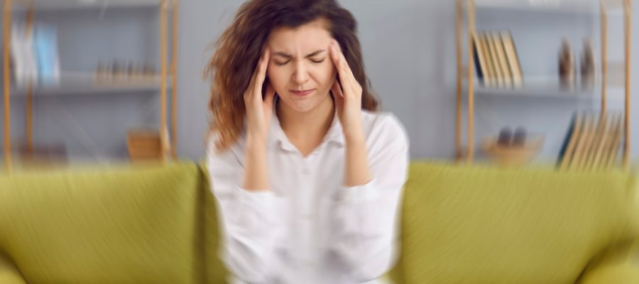 Woman suffering vertigo on a couch