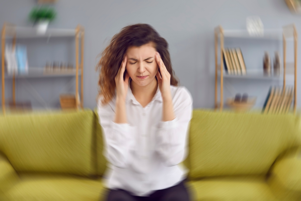 Woman suffering vertigo on a couch